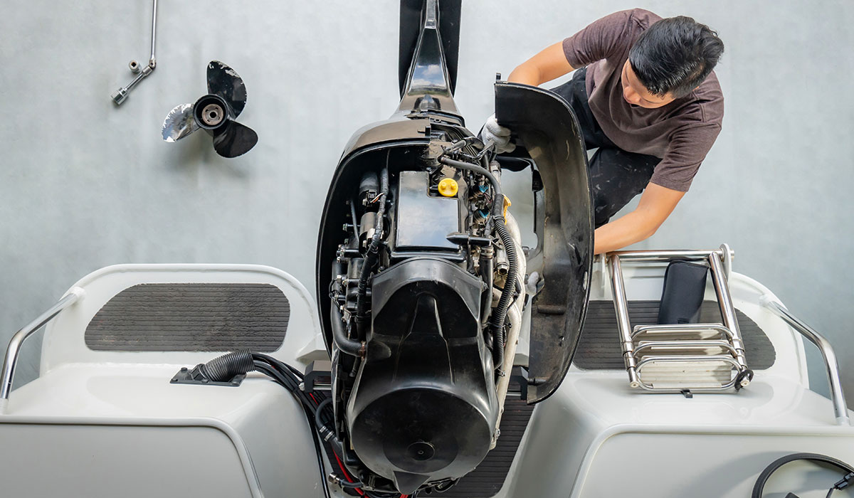 Man repairing engine on boat